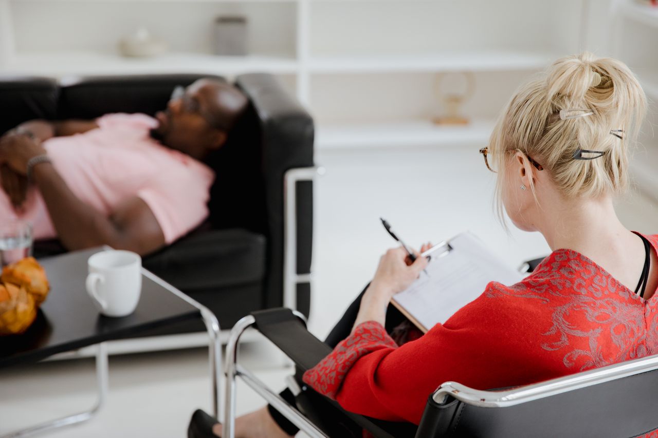 Crafting Captivating Headlines: Your awesome post title goes here A professional therapist takes notes during a therapy session, engaging with a client.